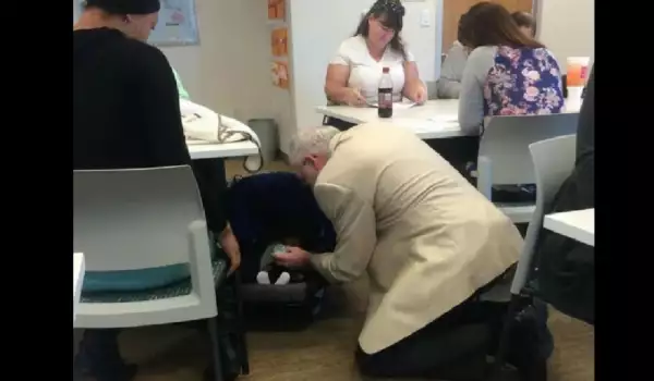 Млад мъж помага на възрастна дама да се прибере до вкъщи.